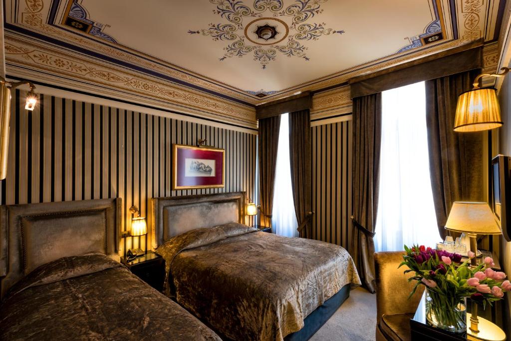 帕特雷梅森格雷科特色酒店的一间卧室配有两张床,在房间内鲜花