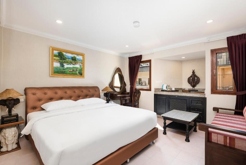 芭堤雅市中心安比恩斯酒店的卧室配有一张白色大床和一张书桌