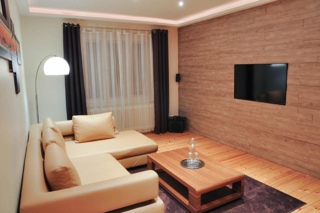 柏林近查理检查站最佳城市之家酒店的客厅配有沙发和墙上的电视