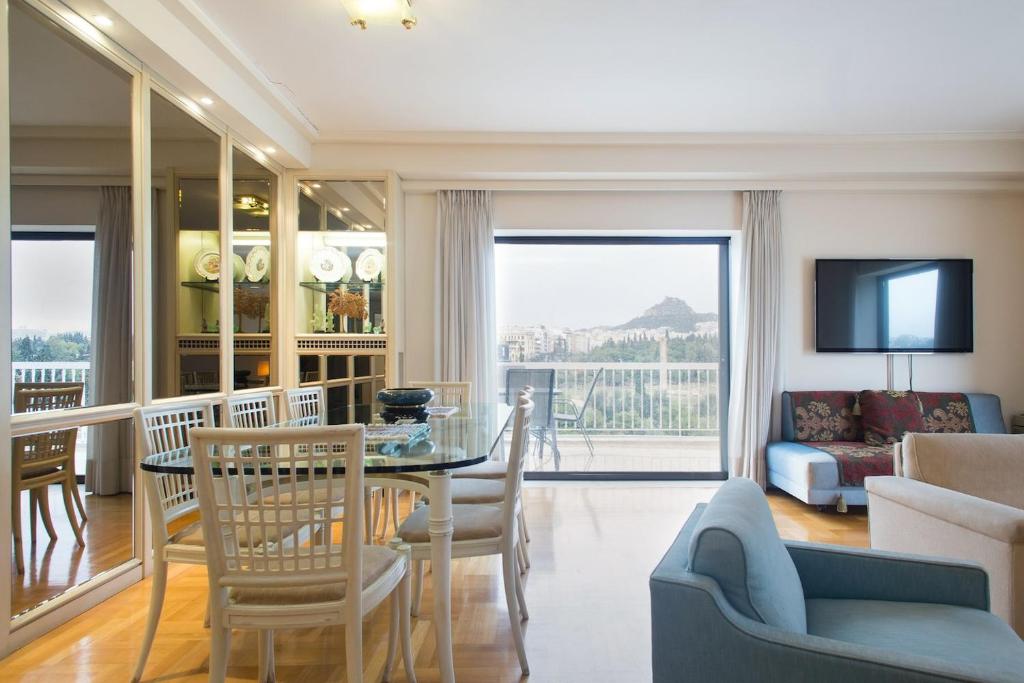 雅典亚历山德斯顶楼公寓的客厅配有桌椅和沙发