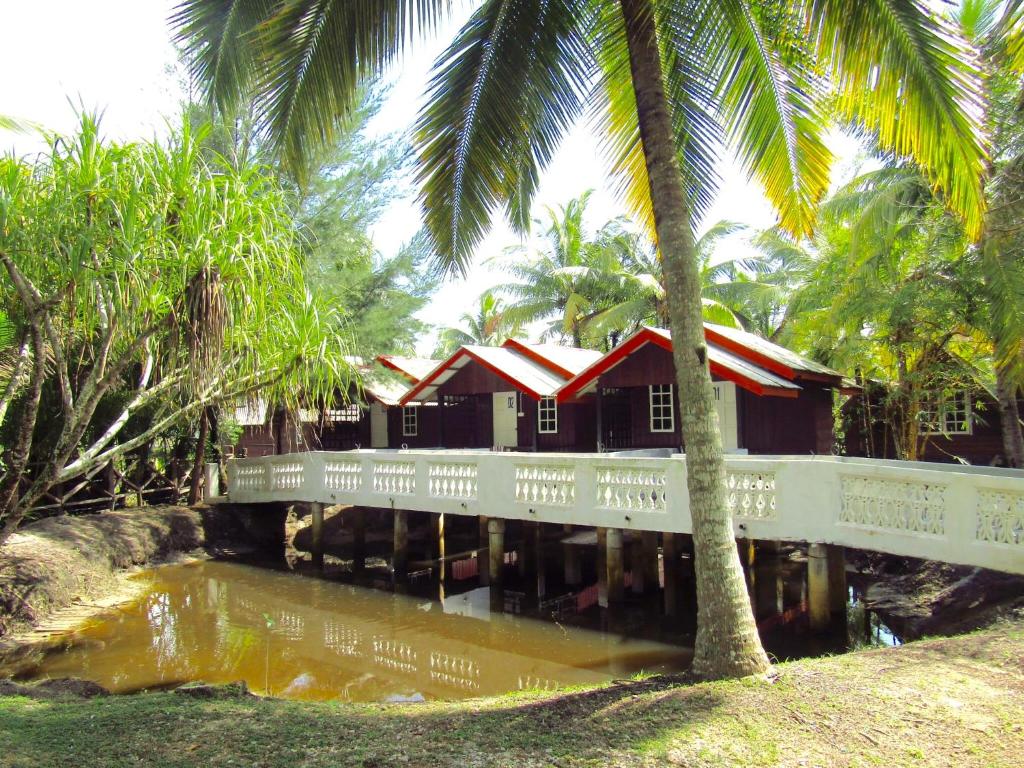 珍拉丁Maznah Guest House的一座有桥和棕榈树的建筑