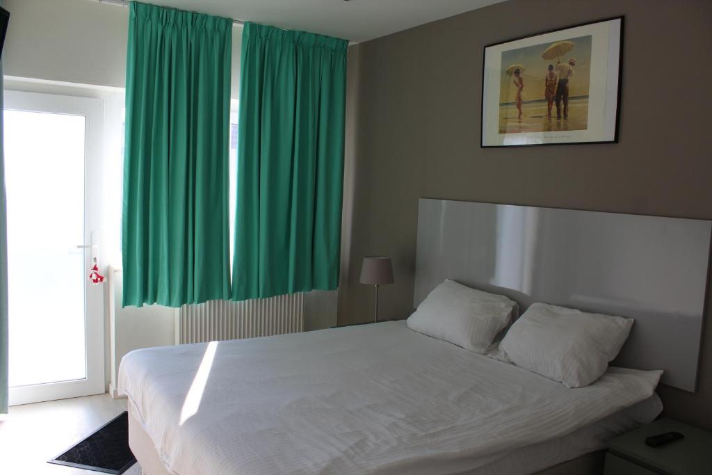 迪尔森-斯托科姆Logie Rotem的卧室配有带绿色窗帘的大型白色床