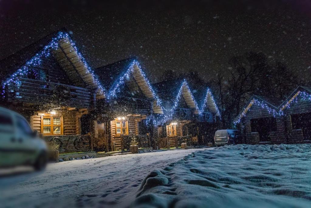 布克维Cottage Hata Zustrich的雪中遮盖着圣诞灯的房子