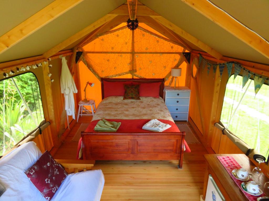 PoharaOmarama Oasis - Permaculture Glamping的帐篷内的卧室,配有一张床