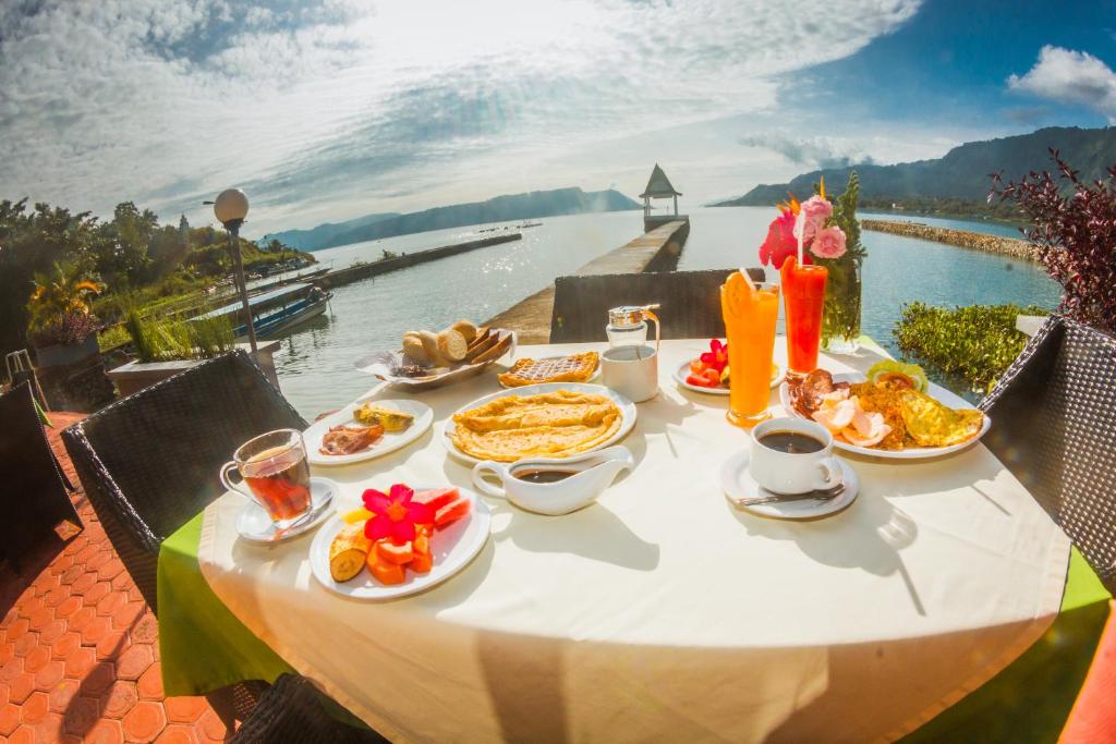 图克图克鸟羽村酒店的一张桌子,上面有食物,享有水景