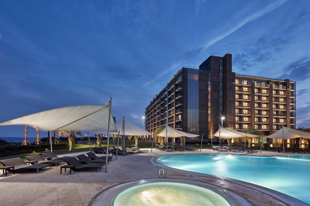 西归浦市济州市海维奇度假酒店的一座带游泳池和大楼的酒店