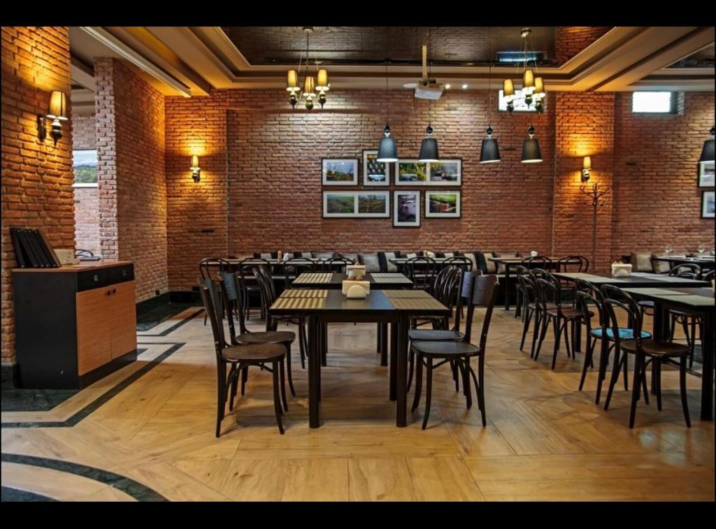 巴库里阿尼Orbi Palace, room 536的一间带桌椅的餐厅以及砖墙