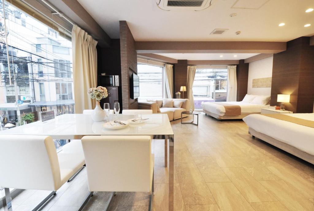 大阪Senlax Inn Osaka的客厅配有餐桌和沙发
