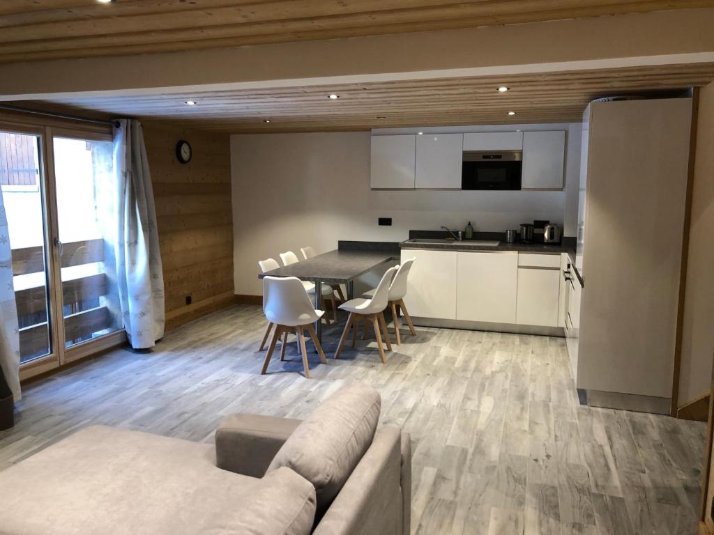 夏蒙尼-勃朗峰Chalet Victoire的客厅以及带沙发和桌子的厨房。