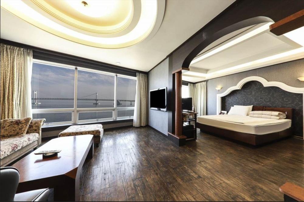 釜山大桥酒店的一间大卧室,配有一张大床和一个大窗户