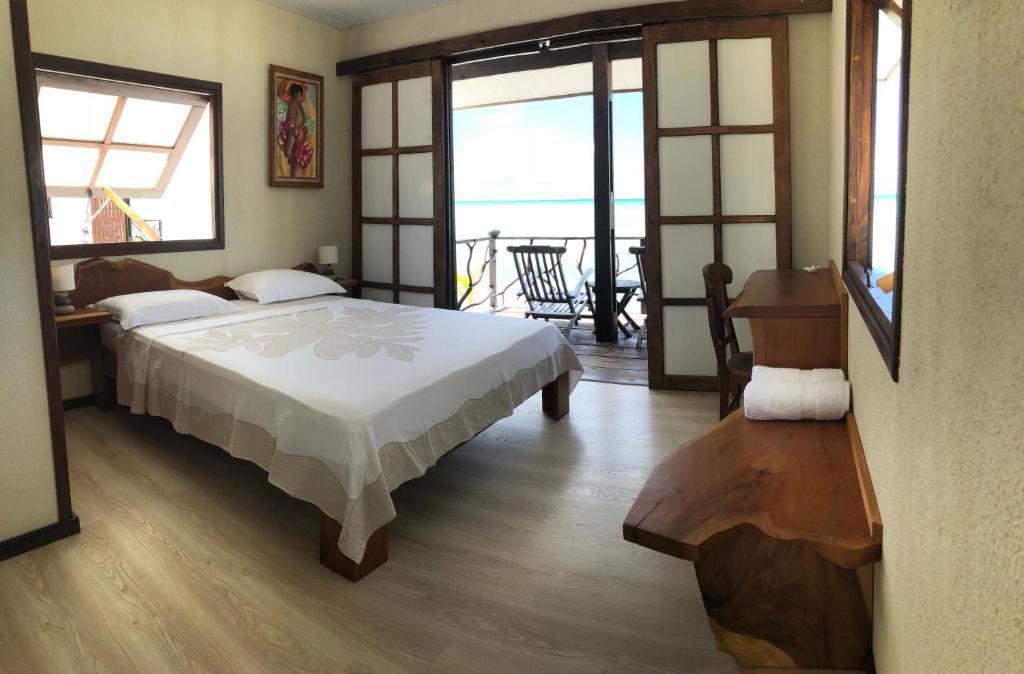提克豪哈卡马努酒店的一间卧室配有一张床,享有海景