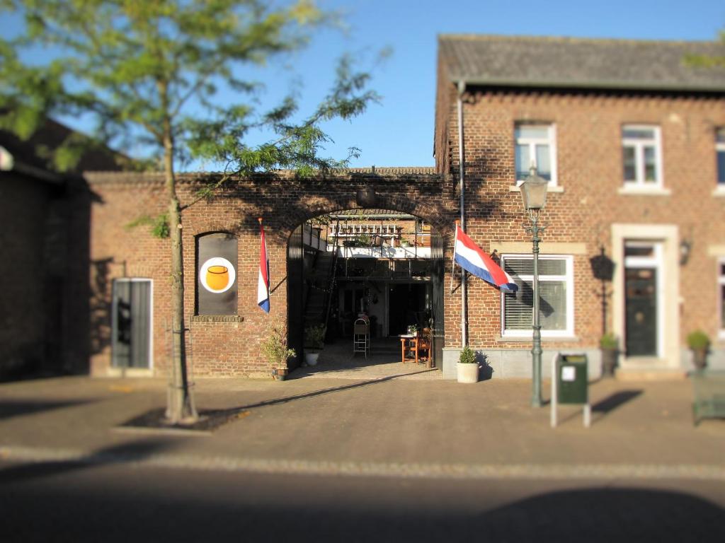 NieuwstadtKoperen keteltje的前面有旗帜的砖砌建筑