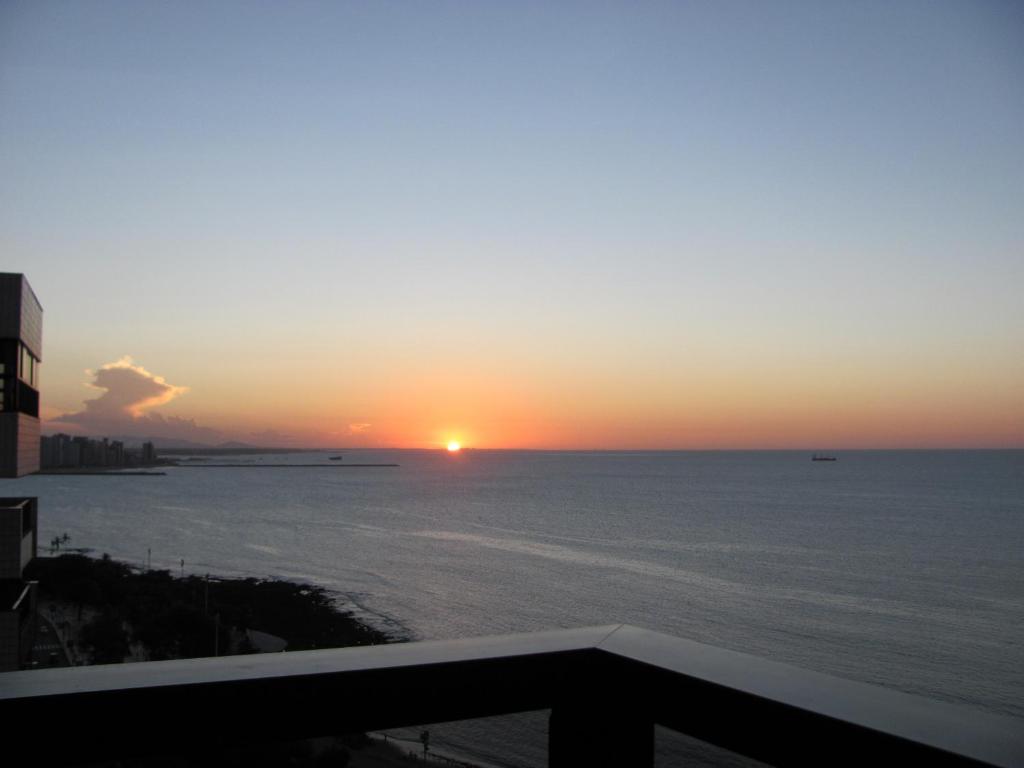 福塔莱萨贵宾伊拉塞马公寓酒店的从阳台上欣赏海洋上的日落