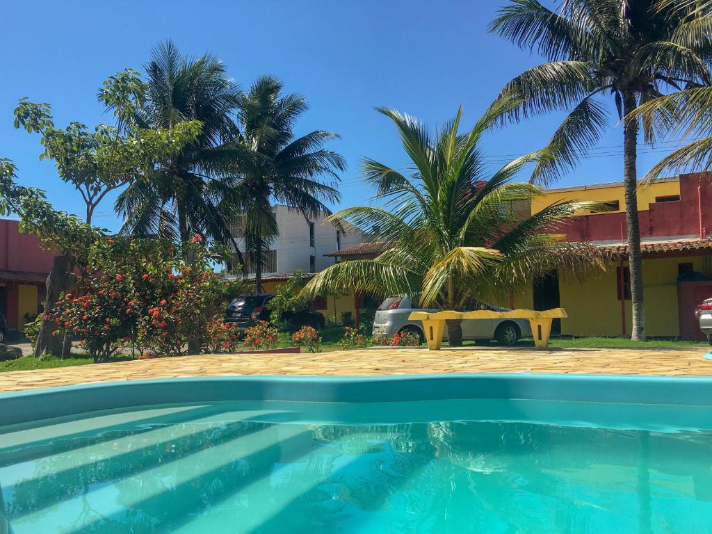 马拉塔伊济斯Pousada dos Gravatais的棕榈树建筑前的游泳池