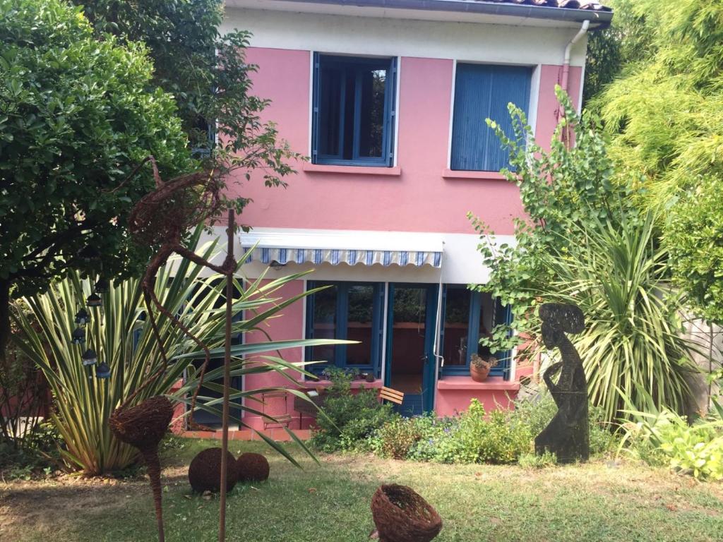 图卢兹CHAMBRE SPACIEUSE DANS MAISON ART DECO au CENTRE DE TOULOUSE的院子里的粉红色房子,有蓝色的门