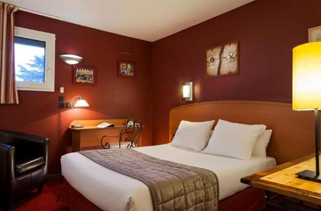 古桑维尔Sky Hotel Goussainville Charles de Gaulle的配有一张床和一张书桌的酒店客房