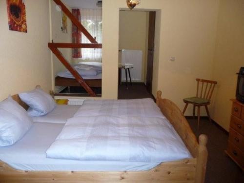 Motten盖斯特霍夫酒店的一间卧室配有一张带白色床单的大床