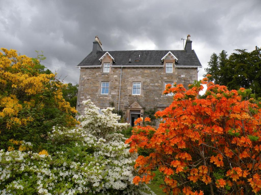 Saint Catherines提斯特尔庄园旅馆的一座古老的石头房子,四周环绕着树木和鲜花