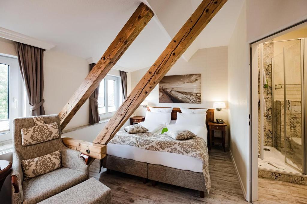 朗格奥HOTEL DÜNENLÄUFER Langeoog的一间卧室配有一张床和一把椅子