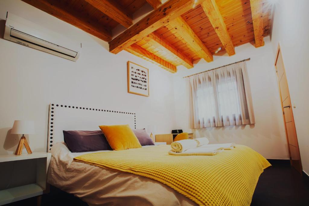 托莱多Dúplex en la Judería de Toledo的一间卧室配有一张带黄色毯子的大床