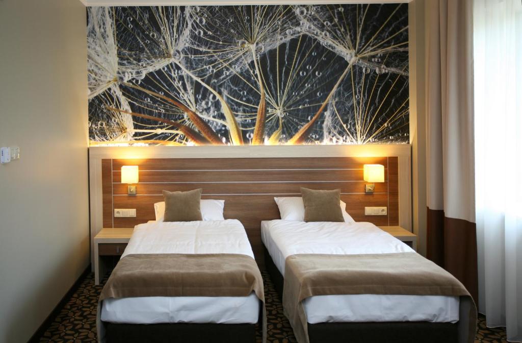 Złotoria德尔菲娜酒店的墙上画画的房间里设有两张床