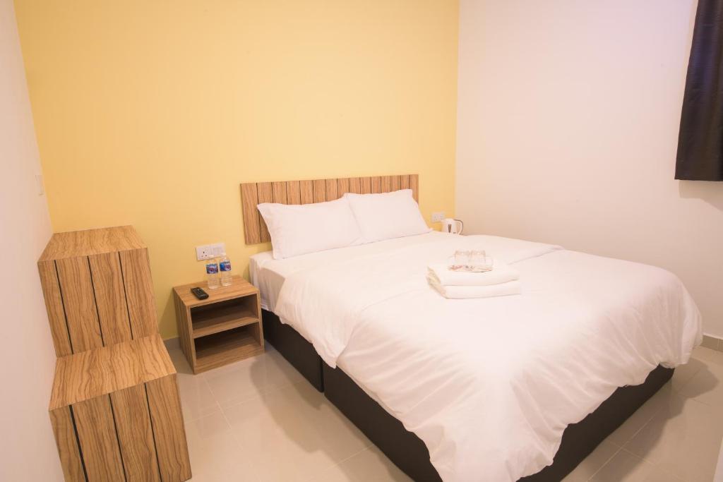 新山LTL Guesthouse的一间卧室配有一张大床和一个床头柜