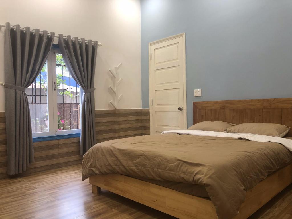 大叻Ruby Dalat Hostel的一间卧室设有一张床和一个窗口