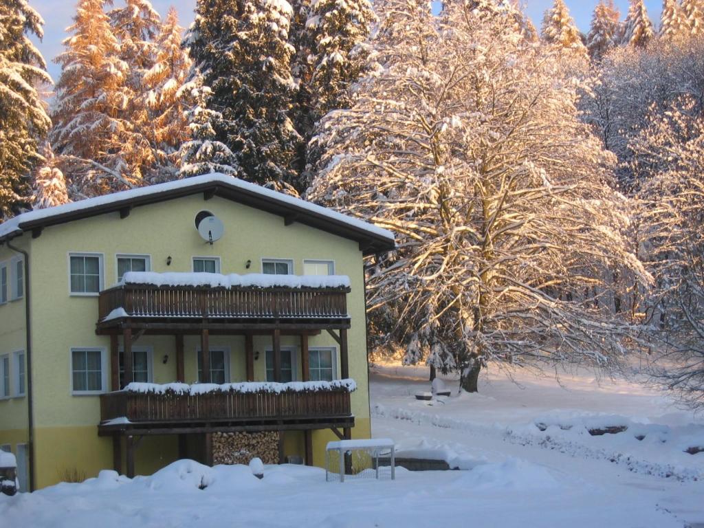 苏尔Feriendorf Waldfrieden的树前的雪覆盖的房子