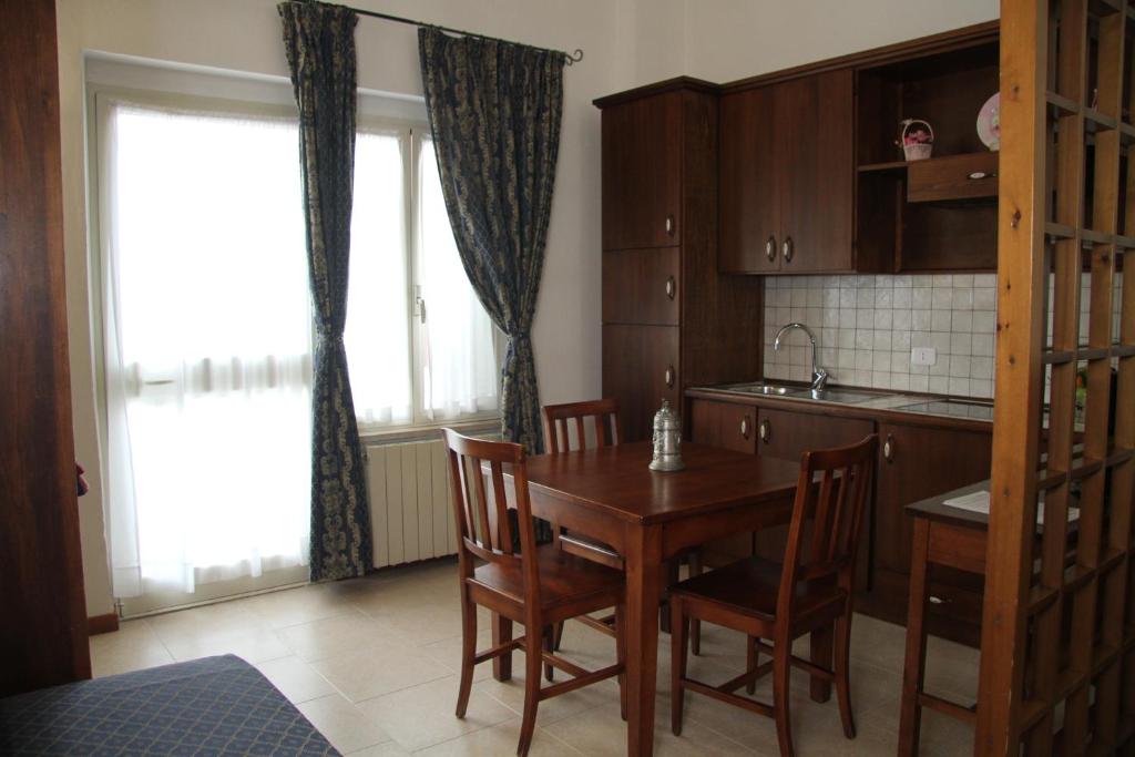 格罗塞托港伊朵皮尼旅馆的厨房配有木桌、椅子和窗户。
