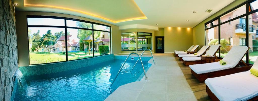 梅洛天堂酒店的一座带几张床和窗户的酒店游泳池