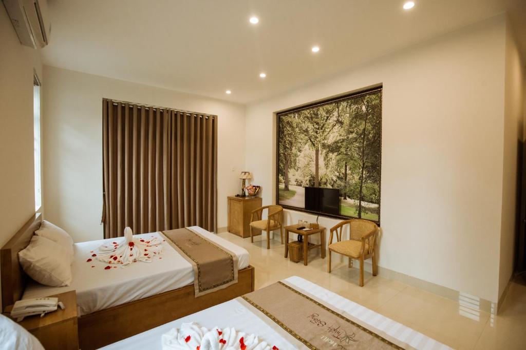 广义Tuyet Suong Villa Hotel的酒店客房设有两张床和窗户。
