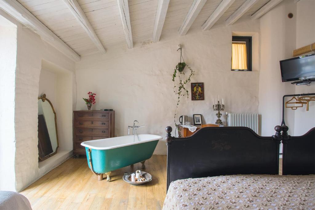 GratteriWUNDERGARTEN Dimora dei Frati的一间带浴缸、床和电视的卧室