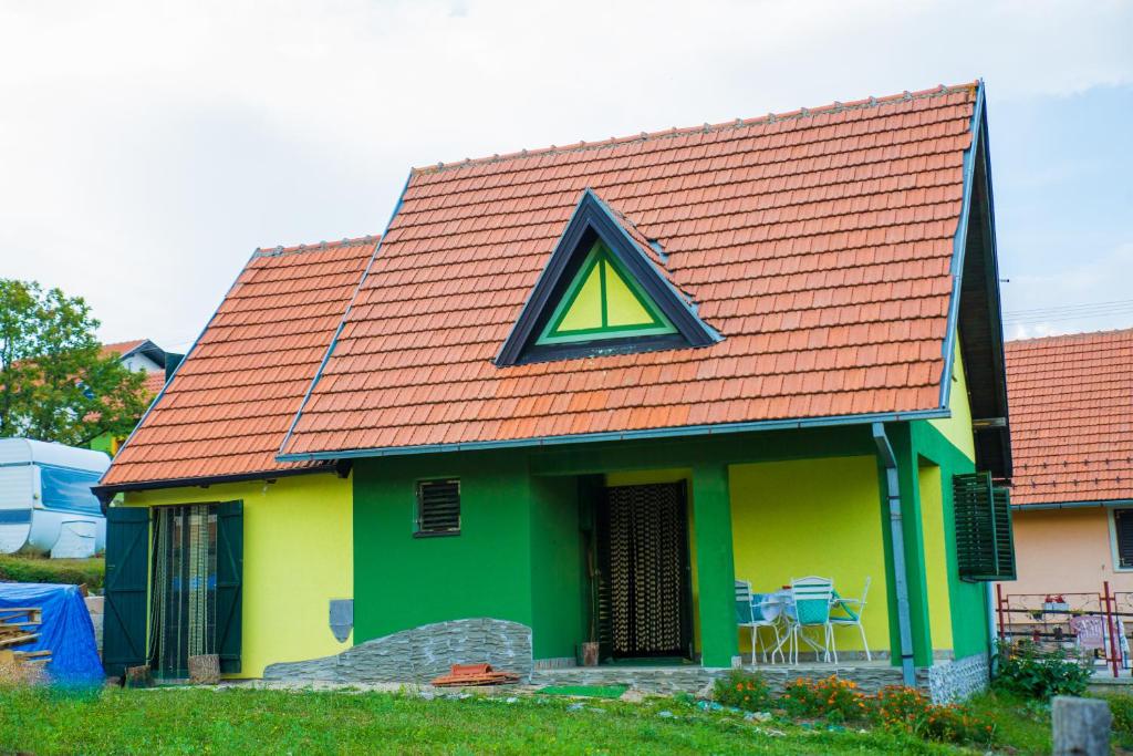 兹拉蒂博尔Vikendica MM的绿色和黄色的房子,设有三角形窗户