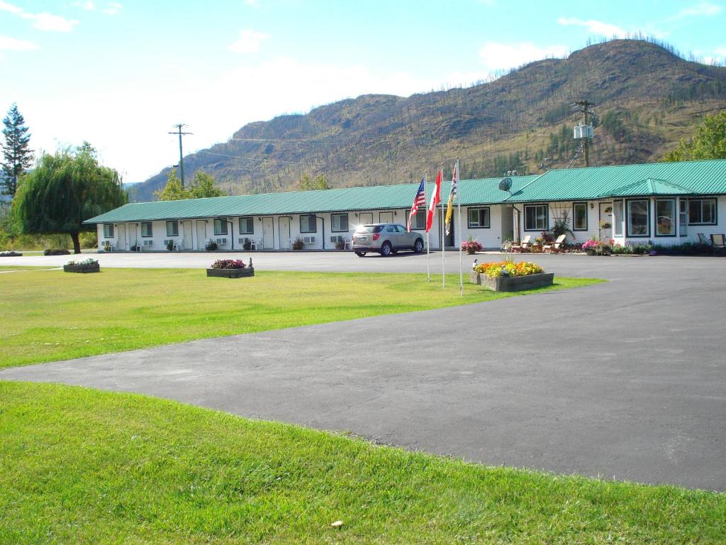 BarrièreMountain Springs Motel & RV Park的前面有两面旗帜的建筑
