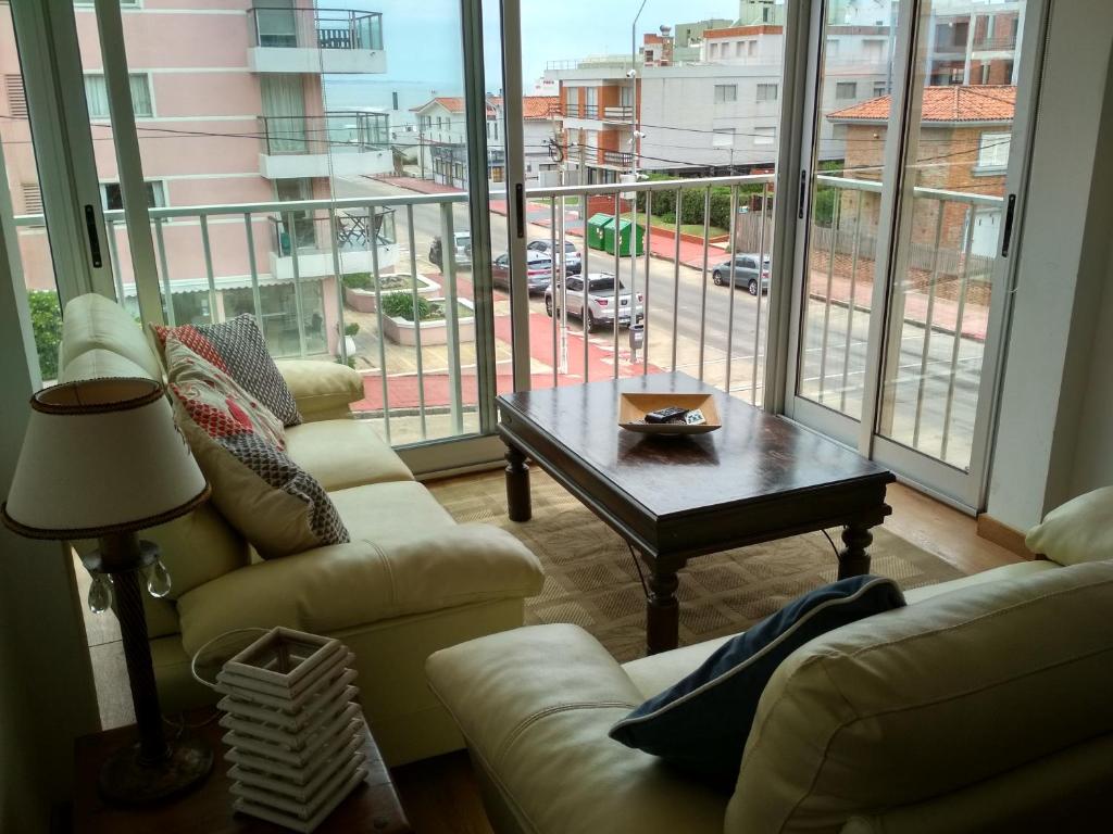 埃斯特角城Club del Mar的客厅设有两张沙发、一张桌子和一个大窗户