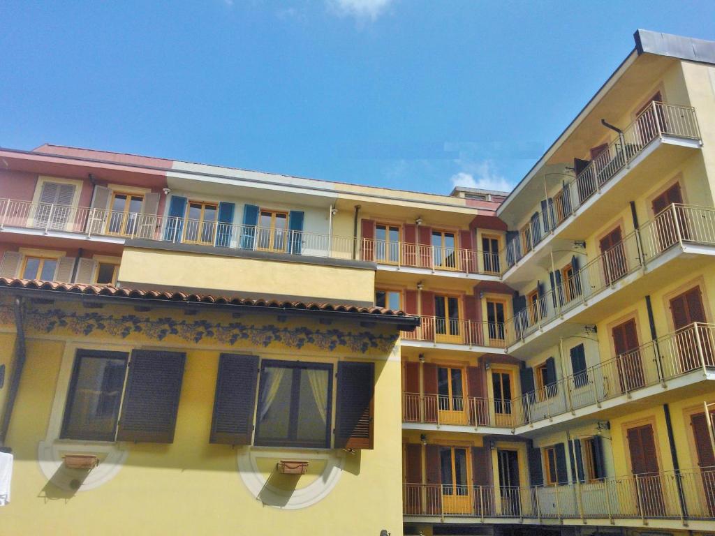 亚历山德里亚科索蒙费拉托住宅酒店的黄色的建筑,旁边设有阳台