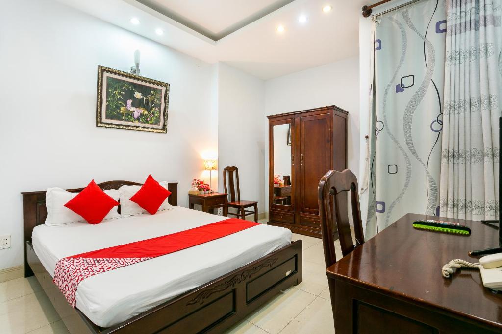 胡志明市Tuan Long Hotel的一间卧室配有一张床、一张书桌和淋浴