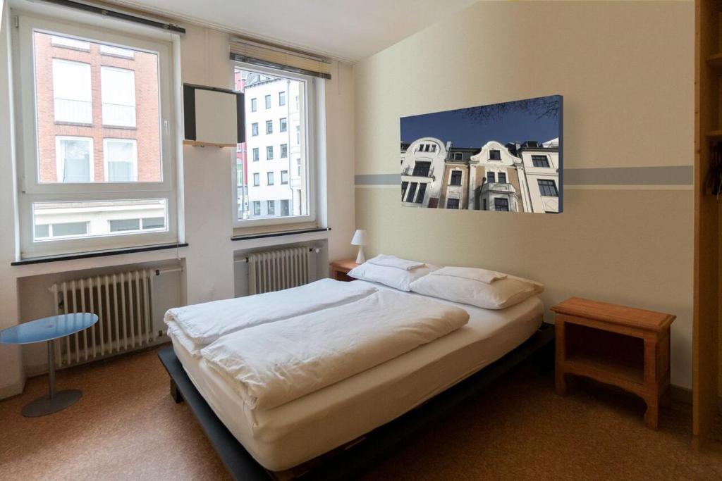 亚琛Hostel Aachen的一间卧室设有一张床和两个窗户。