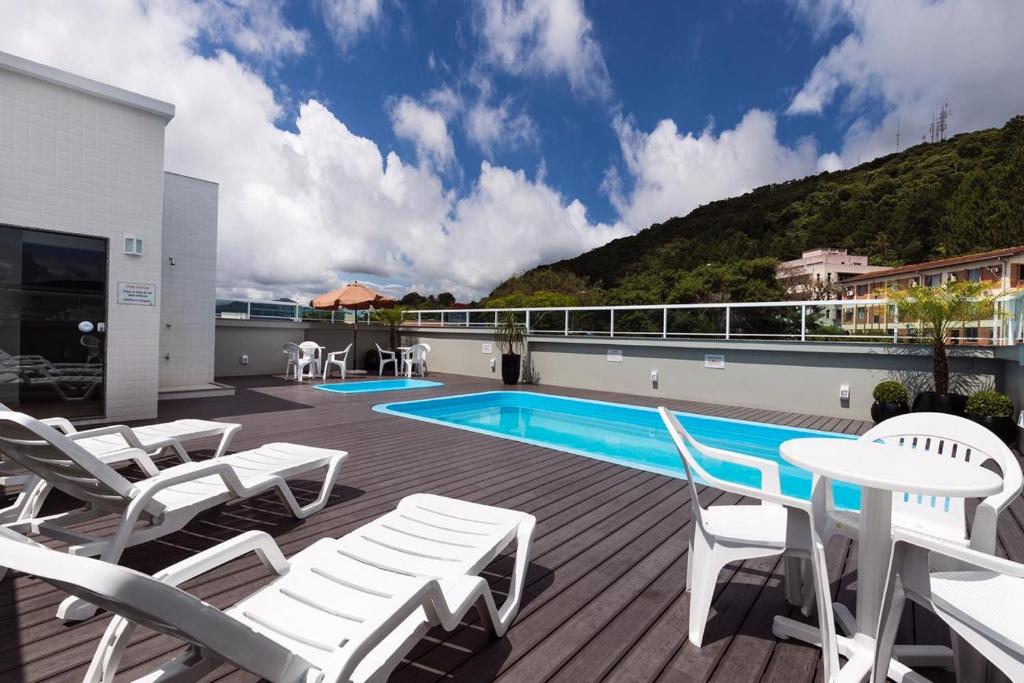 巴拉奈里奥-坎布里乌罗孙布洛克酒店的一个带白色椅子的甲板和游泳池
