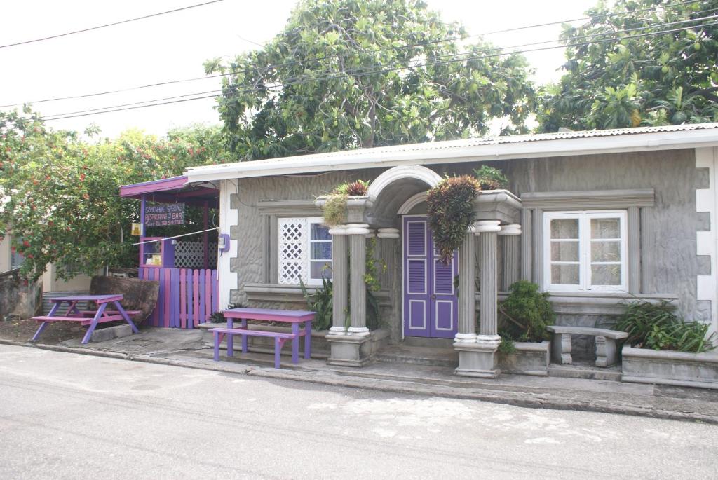 格罗斯岛特别地方旅馆的一座带紫色门和野餐桌的小房子