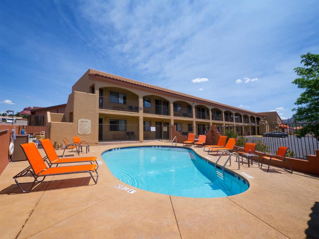 塞多纳Desert Quail Inn Sedona at Bell Rock的一座带游泳池和椅子的酒店和一座建筑