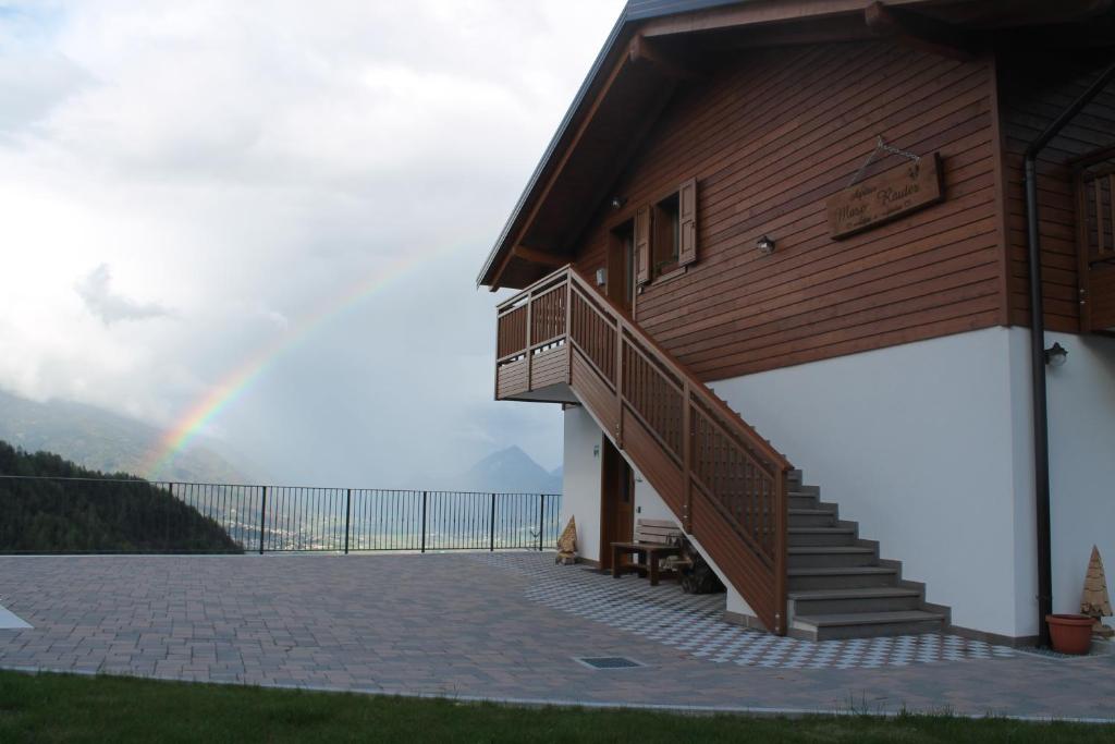 维塔罗玛索劳特住宿加早餐旅馆的彩虹在一座带楼梯和庭院的房子上