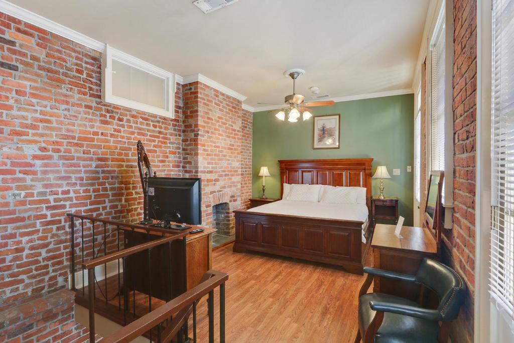 新奥尔良格勒诺布酒店的一间卧室设有一张床和砖墙
