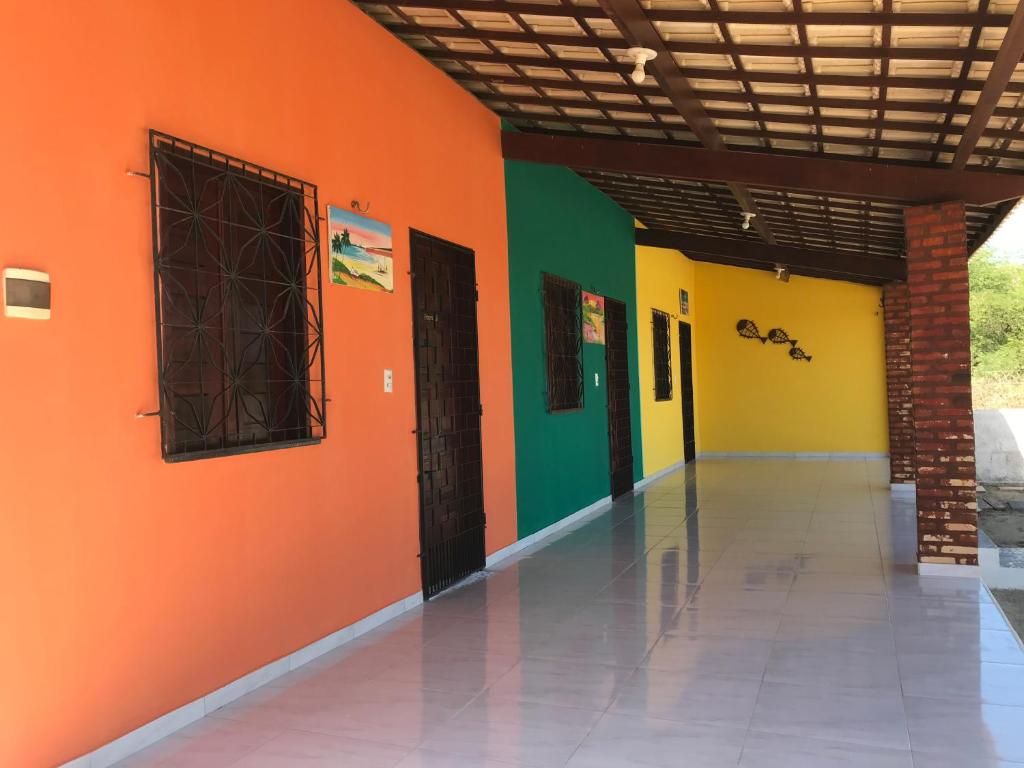 阿拉卡蒂Chalés Porto do Céu的一条空的走廊,有橙色和绿色的墙壁