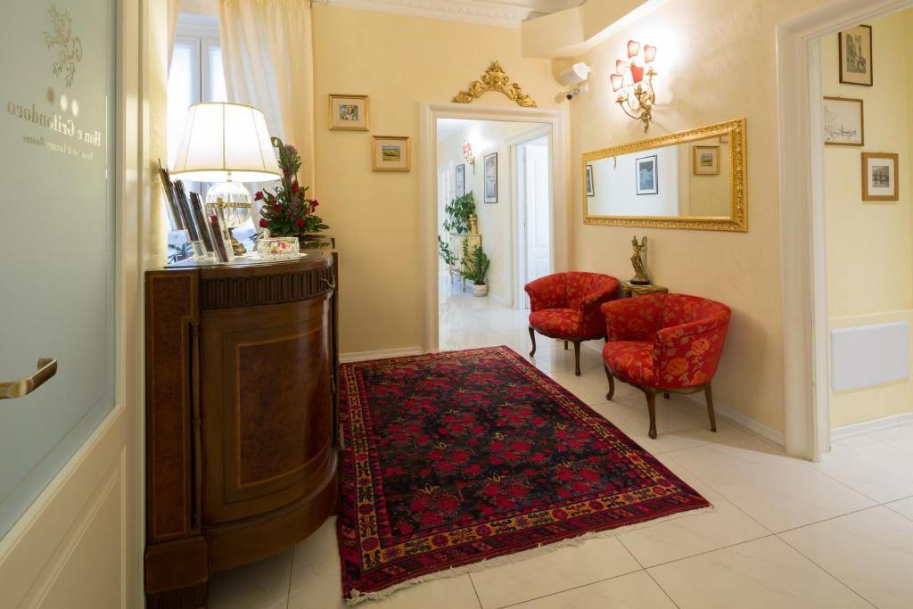 热那亚Home Grifondoro Affittacamere的客厅配有桌子和2把红色椅子