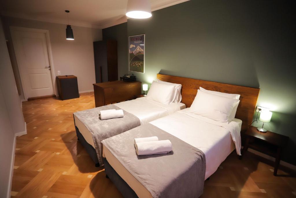 第比利斯HOTEL SABU的酒店客房,配有两张带白色床单的床