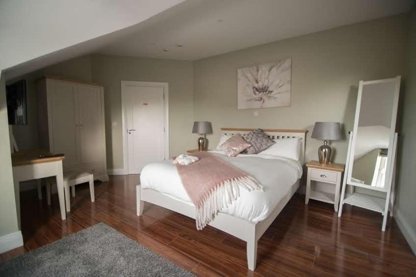 杜林West Haven House的一间卧室配有床、两张桌子和镜子