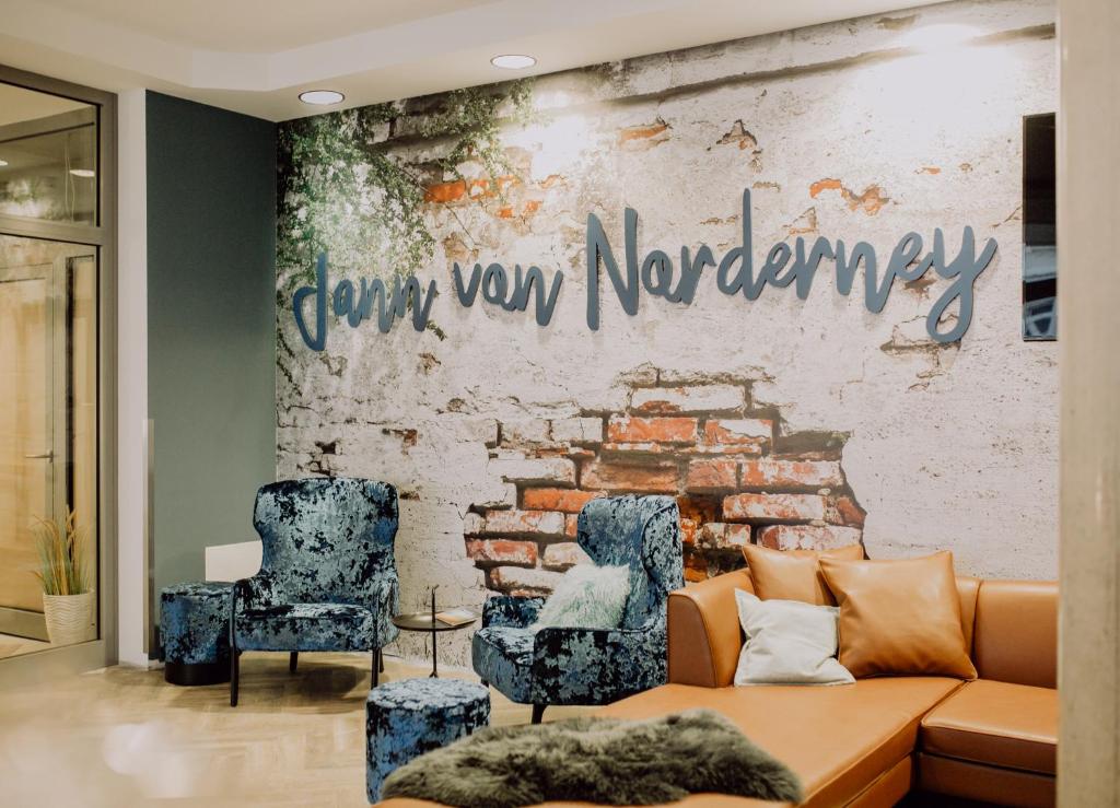 诺德奈Hotel Jann von Norderney的带沙发和砖墙的客厅