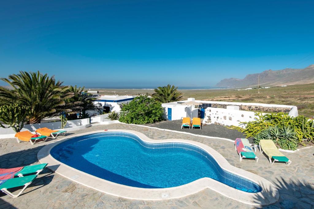 Las Laderas凡卡拉斯维拉得拉斯酒店的一个带椅子和海滩的大型游泳池