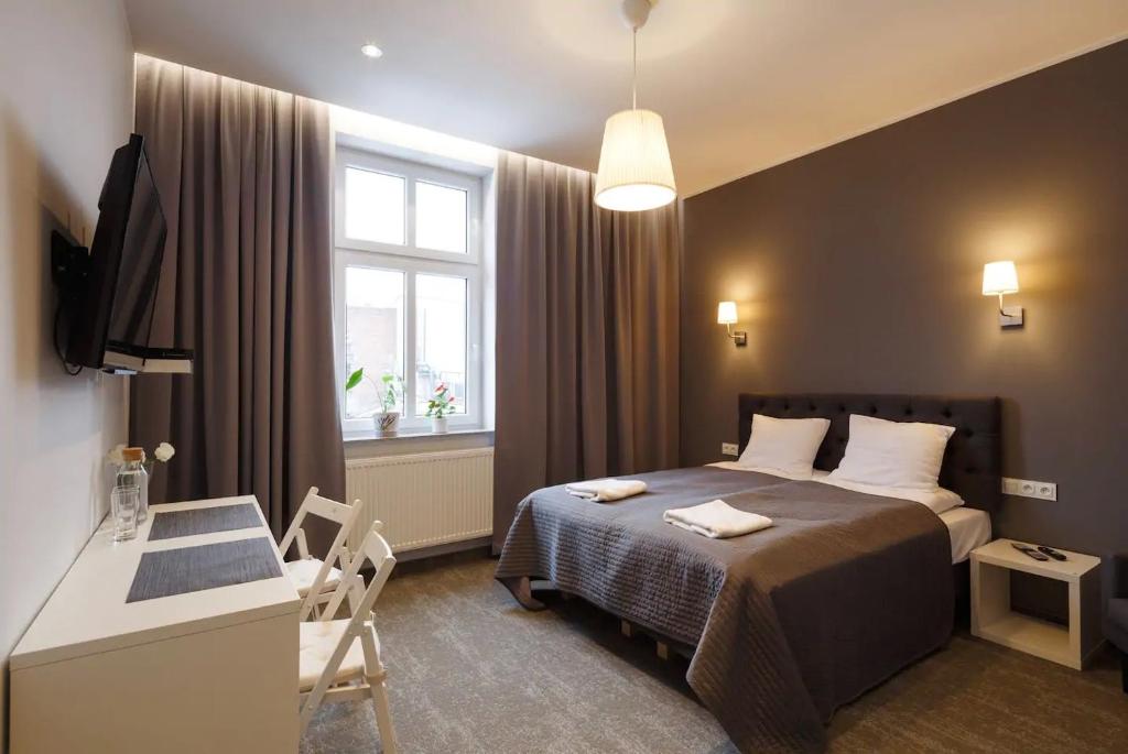卡托维兹Przystanek Katowice Mariacka 26的一间卧室配有一张床、一张书桌和一个窗户。